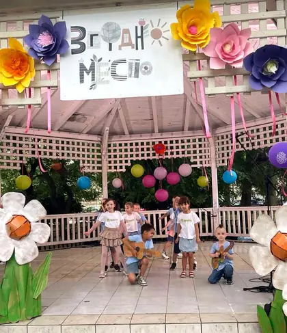 Wooden pavilion decorated with large paper flowers and colourful lanterns