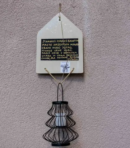 Little house-shaped wooden board with a poem written in yellow chalk
