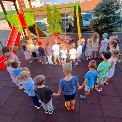 The whole group holding hands in a big circle on the playground