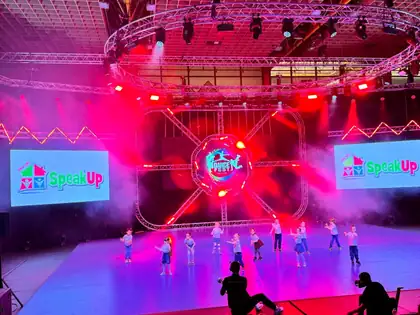 Children dancing under pink and purple stage lights at Dance Fest Novi Sad