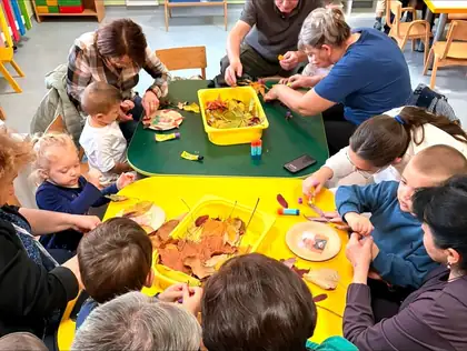 Workshop with grandparents: children and adults making pictures from dry autumn leaves