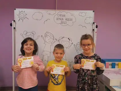 Three children proudly showing their diplomas from the autumn cross-country race